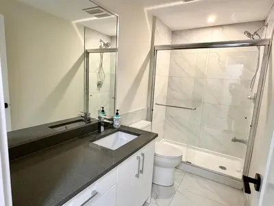 a bathroom with a shower and a sink and a toilet at Sunny White Rock 2BR, Steps to Sand, Brand New Stay in White Rock