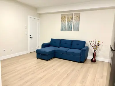a blue couch sitting in a living room at Sunny White Rock 2BR, Steps to Sand, Brand New Stay in White Rock