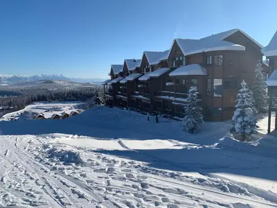 a lodge in the snow with footprints in the snow at Timberstone Lodge by StayIn in Kimberley
