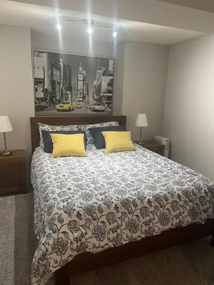 a bedroom with a large bed with yellow and blue pillows at Calgary Lake House B&B in Calgary