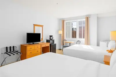 a white bedroom with a bed and a tv at Chic Mountain Hideout in Canmore DT Near Banff! in Canmore