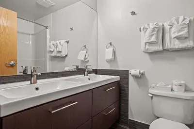 a bathroom with a sink and a toilet and a mirror at Perfect Canmore Getaway for 4 plus Exclusive Savings in Canmore