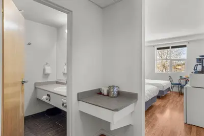a white bathroom with a sink and a bed at Comfy Rockies Retreat for 4 Canmore DT Near Banff in Canmore