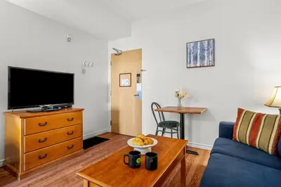 a living room with a blue couch and a tv at Cozy Hideaway with MTN Views Near DT Canmore and Banff in Canmore