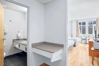 a white bathroom with a sink and a mirror at Canmore Getaway 2 Beds plus Savings in Canmore