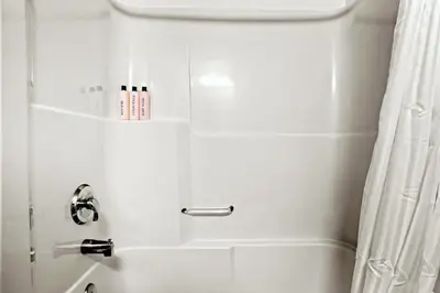 a white bathroom with a shower with a shower curtain at Canmore Getaway 2 Beds plus Savings in Canmore
