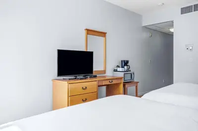 a bedroom with two beds and a television on a dresser at Canmore Getaway 2 Beds plus Savings in Canmore