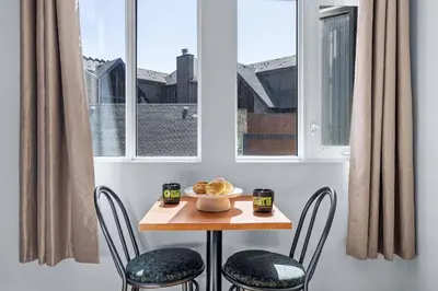 a small table with two chairs and a bowl of food on it at Canmore Getaway 2 Beds plus Savings in Canmore