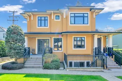 a large yellow house with a gate at 3Bed 2Bath Steam Sauna Retreat! Family friendly! in Vancouver