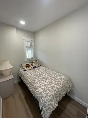 a small bedroom with a bed and a lamp at Private Luxury Relaxing HOME w BBQ & Gas Fire-pit in Hope