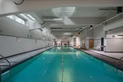 a large swimming pool with blue water in a building at Bright 3BR Downtown Vancouver Condo w Pool & Gym in Vancouver