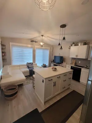 a kitchen and living room with a couch and a table at Creekside Oasis on Mara in Sicamous