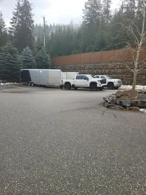 a white truck and a white trailer parked in a parking lot at Creekside Oasis on Mara in Sicamous