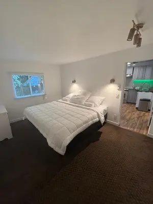 a bedroom with a large white bed with a window at Sasha-Home 538 Brookmere Ave in Coquitlam