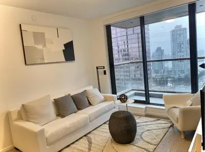 a living room with a couch and a large window at Brand New Luxury 1 bedroom Condo in Downtown Vancouver in Vancouver