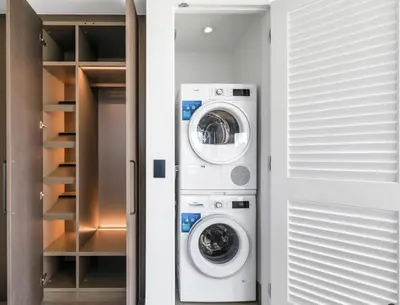 a laundry room with a washer and dryer next to a closet at Brand New Modern 2 BR Condo in Heart of Downtown Vancouver in Vancouver