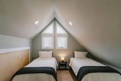 a attic room with two beds and a window at Abraham - Peaceful cabin in historic Nordegg in Nordegg