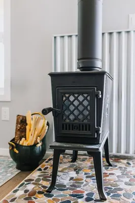 a black stove sitting on a rug in a room at Abraham - Peaceful cabin in historic Nordegg in Nordegg