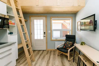 a room with a desk and a ladder and a chair at Adventure Knap Shack in Nordegg
