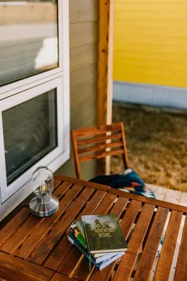 a wooden table with a book and a candle on it at Baldy- Modern tiny home in historic Nordegg in Nordegg