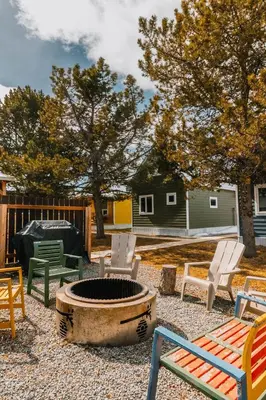 a yard with chairs and a fire pit and a house at Baldy- Modern tiny home in historic Nordegg in Nordegg