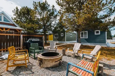 a group of chairs sitting around a fire pit at Baldy- Modern tiny home in historic Nordegg in Nordegg