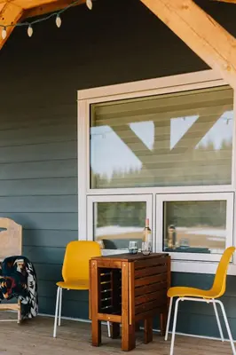 a patio with two chairs and a table and a window at Coliseum - Get Back to Nature in Nordegg