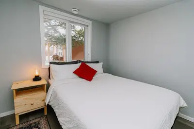 a bedroom with a white bed and a window at Eagle - Cozy tiny home with mountain views in Nordegg