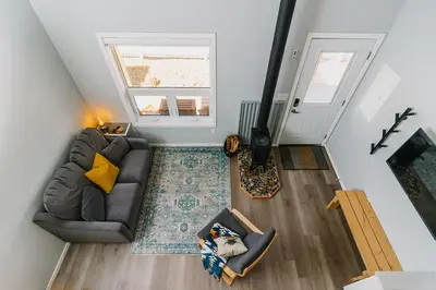 an overhead view of a living room with a couch and a window at Eagle - Cozy tiny home with mountain views in Nordegg