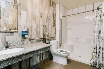 a bathroom with a toilet and a sink and a tub at Trailhead Tuck-Inn in Nordegg