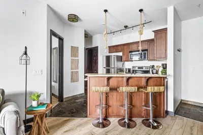 an open kitchen with a counter and stools at Chic Rockies Getaway - Pool & Hot Tub - King Bed - BBQ! in Canmore