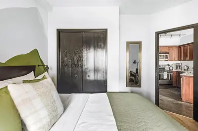 a bedroom with a bed and a large door at Chic Rockies Getaway - Pool & Hot Tub - King Bed - BBQ! in Canmore