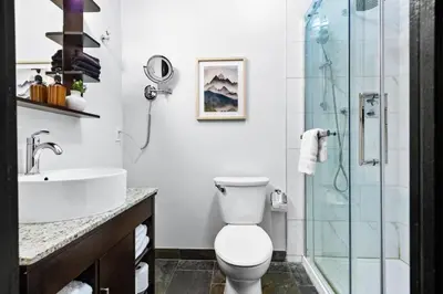 a bathroom with a toilet and a sink and a shower at Chic Rockies Getaway - Pool & Hot Tub - King Bed - BBQ! in Canmore