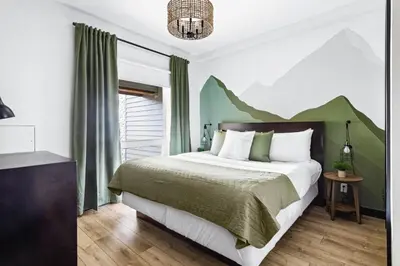 a bedroom with a bed with a mountain mural on the wall at Chic Rockies Getaway - Pool & Hot Tub - King Bed - BBQ! in Canmore