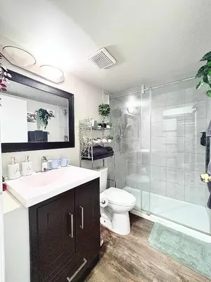 a bathroom with a sink and a shower and a toilet at Stylish Downtown Condo near Rogers Place l Parking, Gym, Balcony & Kitchen in Edmonton