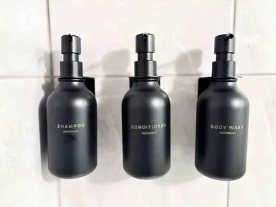 a group of three black bottles sitting on a counter at Stylish Downtown Condo near Rogers Place l Parking, Gym, Balcony & Kitchen in Edmonton