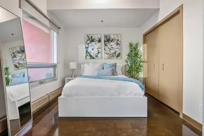 a bedroom with a large white bed and a window at The Chic Downtown Residence | Luxe + Free Parking in Calgary