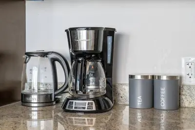 a blender and two cups on a counter at Downtown Chic Retreat | Elegant + Free Parking in Calgary