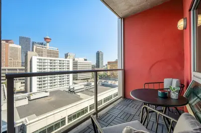 a balcony with a table and chairs and a view of the city at Downtown Chic Retreat | Elegant + Free Parking in Calgary