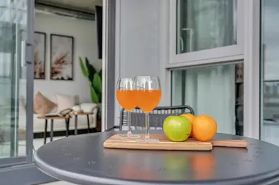 two glasses of wine and fruit on a table at Stylish Beltline 1BR w/ Parking in Calgary