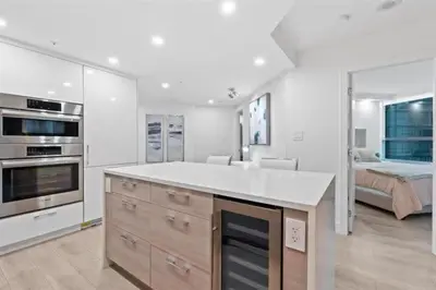 a kitchen with a white counter top and a bedroom at Executive Downtown Suite with Great City Views in Vancouver