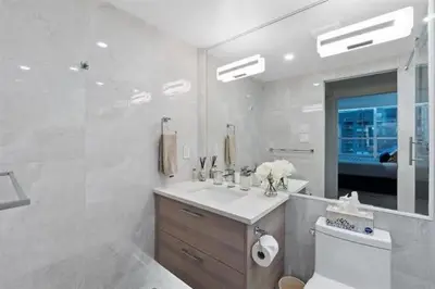 a bathroom with a sink and a toilet and a mirror at Executive Downtown Suite with Great City Views in Vancouver