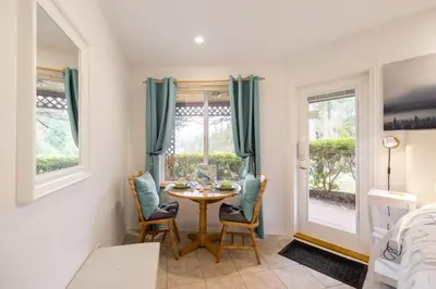 a dining room with a table and chairs and a window at Enchanter Ocean View Suites in Madeira Park