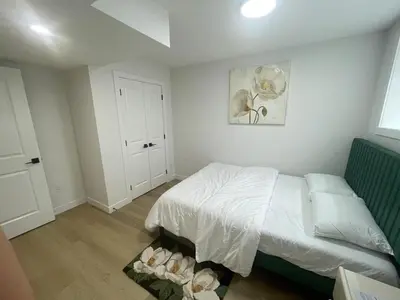 a bedroom with a white bed and a white cabinet at Your Cozy Happy Place in Calgary