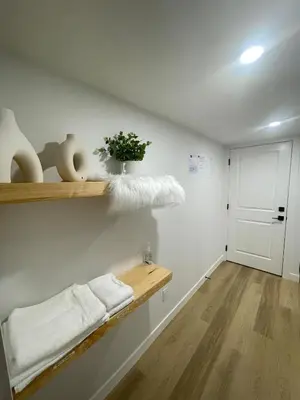 a room with a shelf with towels and a door at Your Cozy Happy Place in Calgary
