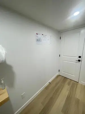 a white room with a door and a wooden floor at Your Cozy Happy Place in Calgary