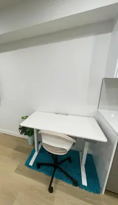 a white desk in a room with a white wall at Your Cozy Happy Place in Calgary