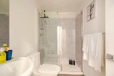 a bathroom with a shower and a toilet and a sink at Victoria's Family Oceanside Retreat, brand new 2br basement in Colwood