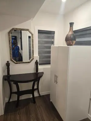 a room with a mirror and a table and a vase at Cozy 2-Bedroom Suite 5 Minutes Walk to Chestermere Lake in Chestermere