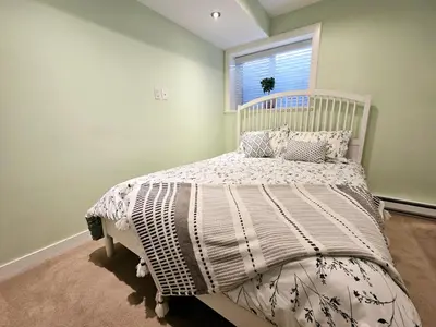 a white bed in a bedroom with a window at The open nest in Delta